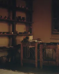 The Circle performance room – shelves of ceramics beside Huh Namhoon's cabled sound equipment in warm light
