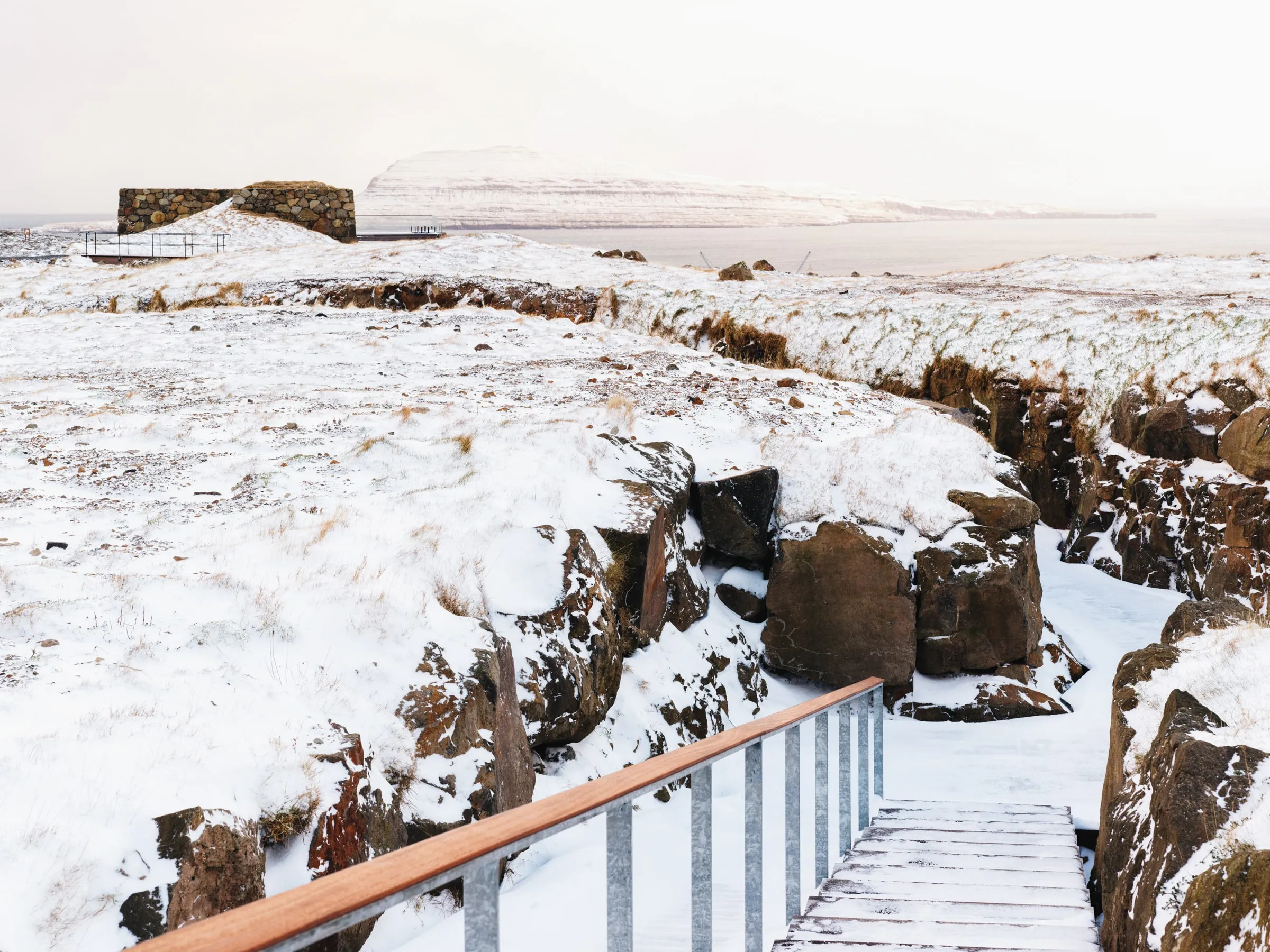 The walkway to Ress Spa in snow, Tórshavn harbour beyond