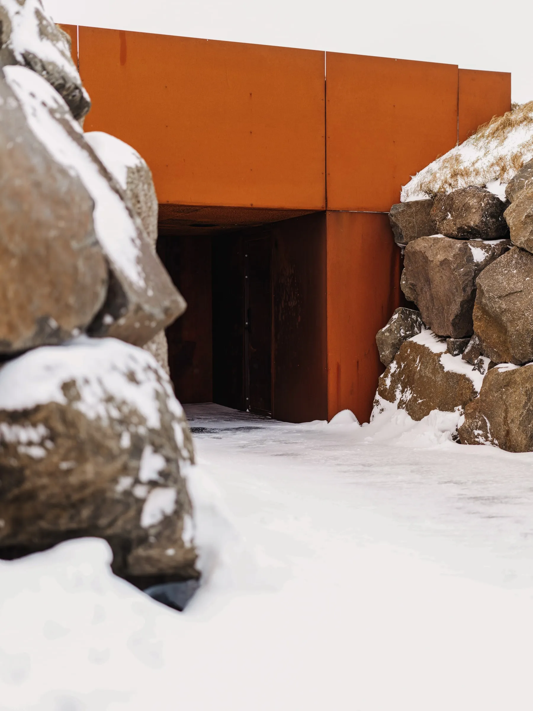 Snow on the rock and the corten entrance of the spa house