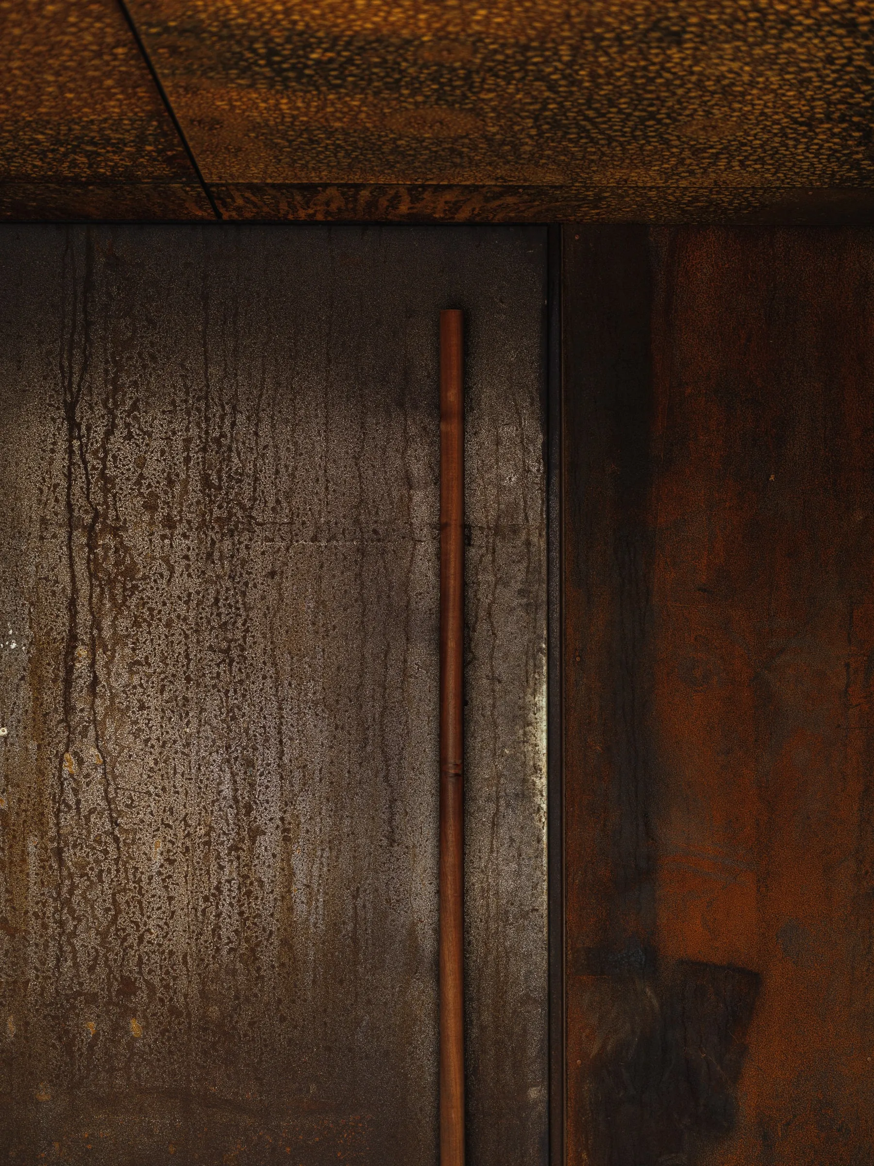 The corten steel wall of Ress Spa, set into the rock of the hillside above Tórshavn