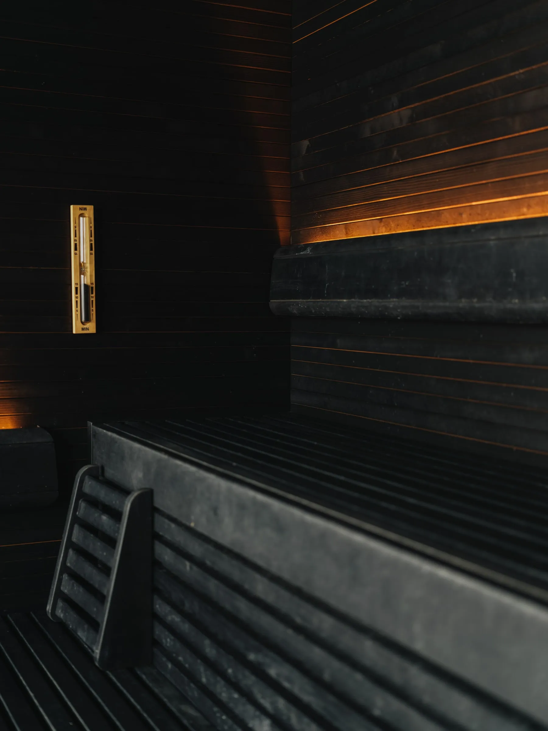 The dark timber sauna, and steam in the stone-clad steam bath