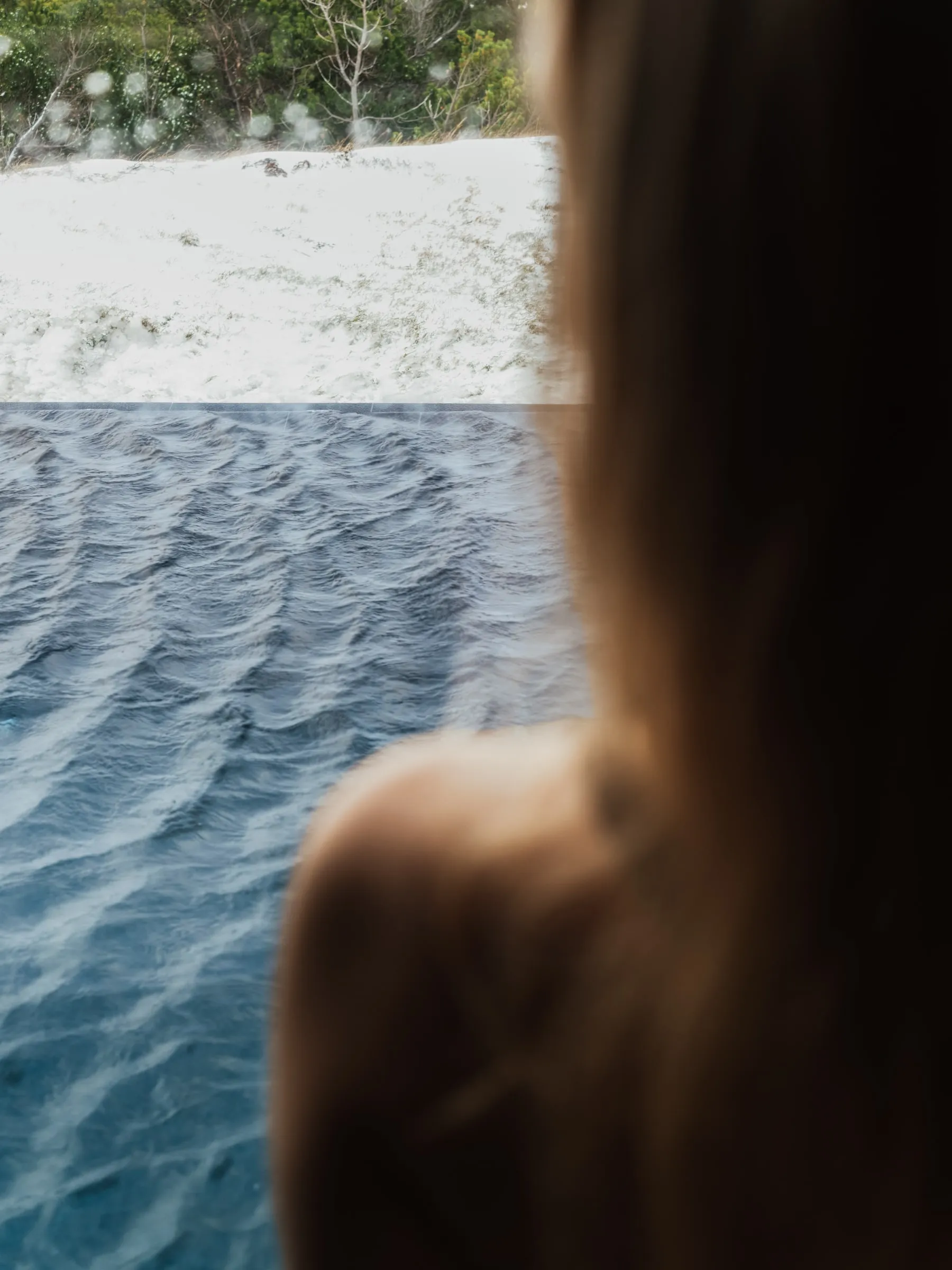 The pool seen past a bather's shoulder, and the walk from the shower to the pool