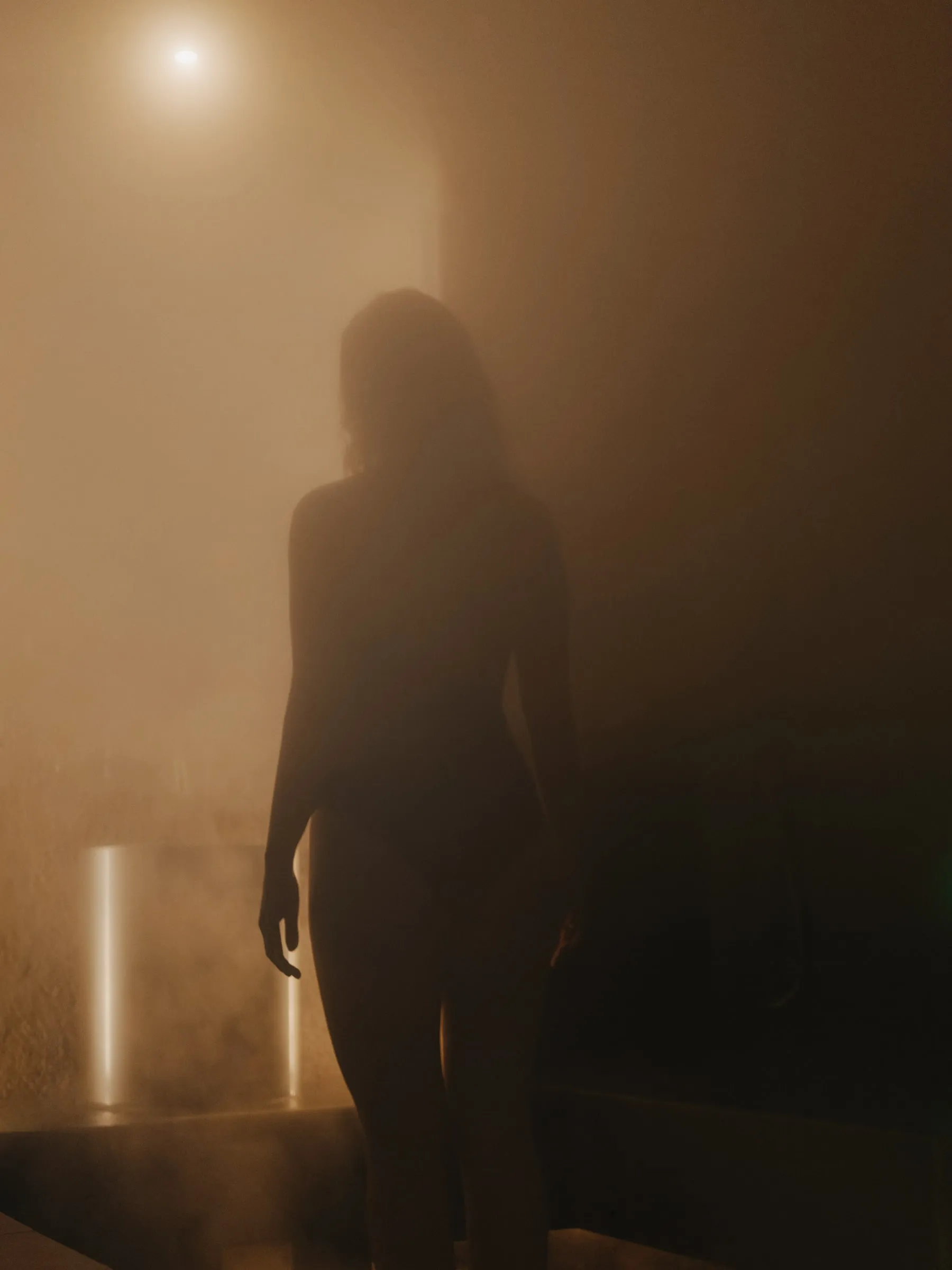 A bather in silhouette in the steam
